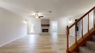 Unfurnished living room featuring ceiling fan, lig