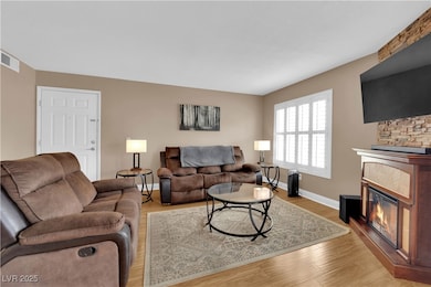 Living area with a glass covered fireplace, basebo