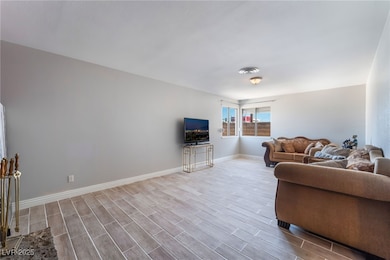 Living area with baseboards and wood finished floo