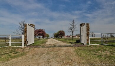 Front gate opens to a wide gravel drive way