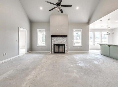 Unfurnished living room featuring a stone fireplac