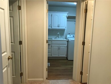 Laundry and garage entry located off hallway near Master bedroom and guest 1/2 bath.  Cabinets and sink add to convenience of this utility room.
