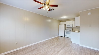Kitchen with white appliances, light wood-style fl