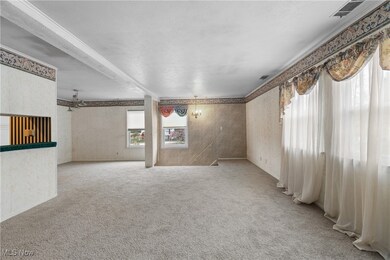 Unfurnished living room with wallpapered walls and light carpet