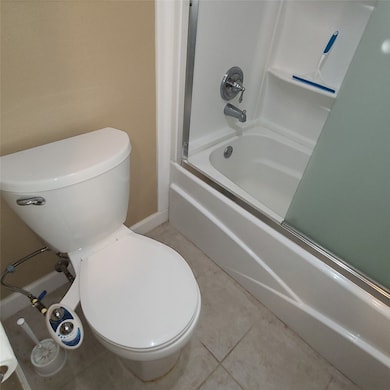 Newer Tub with Glass Sliding Doors and a Toilet wi