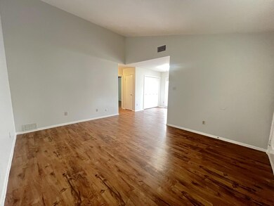 Unfurnished room featuring vaulted ceiling, wood 