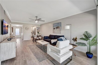 Living room with ceiling fan and ornamental moldin