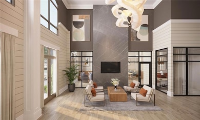 Living room featuring a high ceiling, ornamental molding, a premium fireplace, and hardwood / wood-style flooring