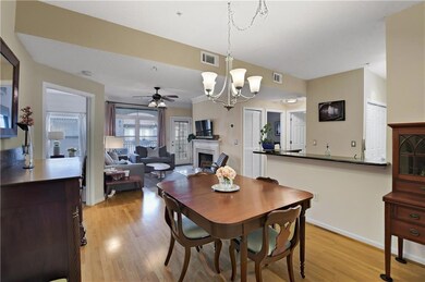 Dining area with a fireplace, light wood flooring, a chandelier, and ceiling fan