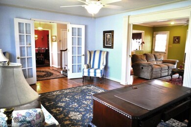 Spacious formal living room with hardwood floors and beautiful double doors leading from main hall