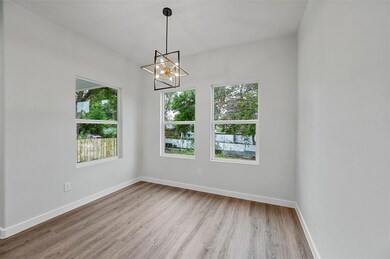 Kitchen featuring light stone counters, white cabi