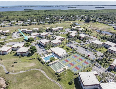 Aerial view of residential area with a nearby body of water and a pool area