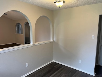 Spare room featuring a textured ceiling and dark wood-style flooring