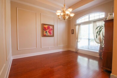 Empty room with a tray ceiling, a notable chandeli