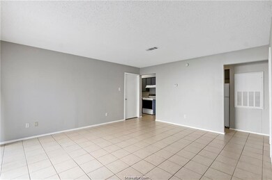 Spare room with a textured ceiling and light tile