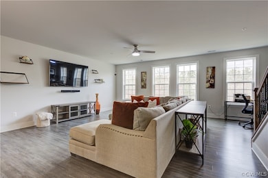 Living room featuring ceiling fan and wood-type fl
