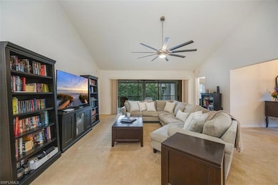 Living area featuring a ceiling fan, high vaulted 