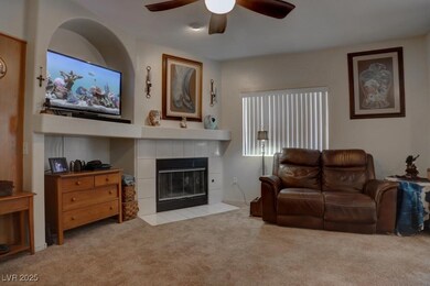 Carpeted living room featuring ceiling fan and a t