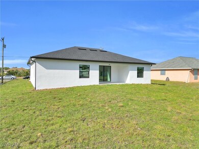 Back of property featuring a lawn and stucco sidin