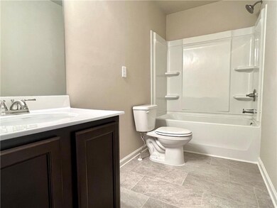 Full bathroom featuring baseboards, vanity, toilet, and washtub / shower combination