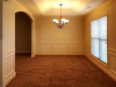 Unfurnished room with a chandelier, arched walkway