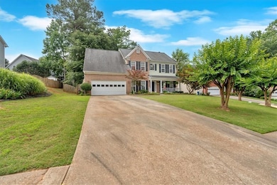 Colonial inspired home featuring concrete driveway, an attached garage, and covered porch