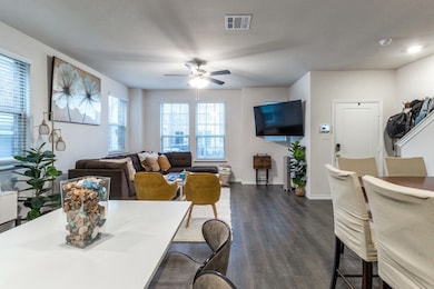 Living room with dark wood-style flooring and a ceiling fan