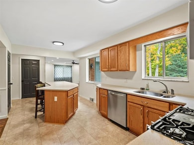 Kitchen with light countertops, healthy amount of natural light, a breakfast bar, and brown cabinets