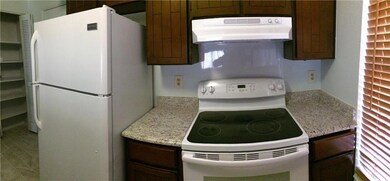 The kitchen has a granite counter, refri