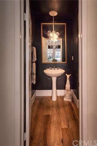 Powder bath features chandelier and custom mirror.