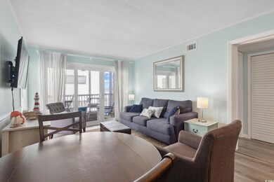 Living room with wood finished floors and ornamental molding