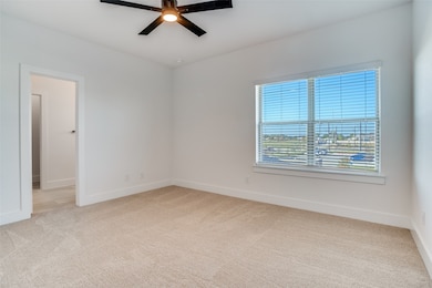 Upstairs Primary room with light carpet and ceiling fan