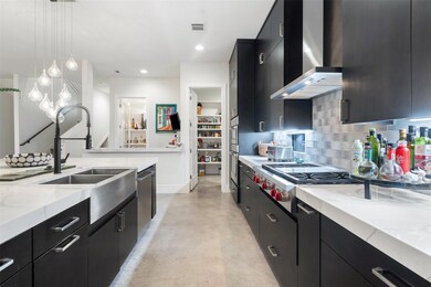Kitchen with wall chimney exhaust hood, dark cabi