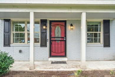 View of exterior entry featuring covered porch