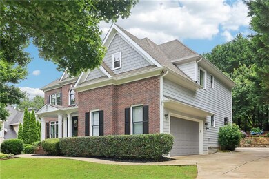 View of front of house featuring driveway, a garage, brick siding, a front yard, and roof with shingles
