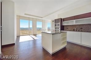 Kitchen with dark countertops, dark wood-type floo