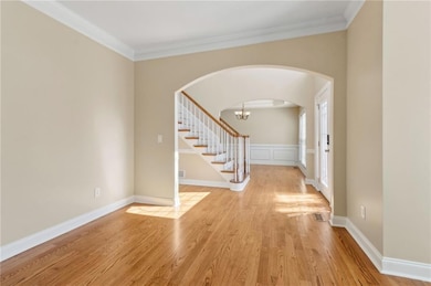 Foyer with crown molding, light wood-type flooring