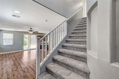 Stairway featuring wood finished floors, ceiling f