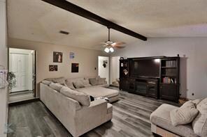 Living area with vaulted ceiling with beams, ceili