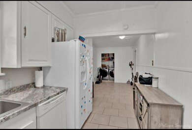 Kitchen with washing machine and dryer, white cabi
