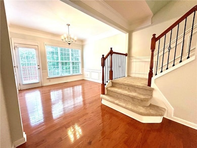 Half bathroom with crown molding, wood finished floors, toilet, and baseboards