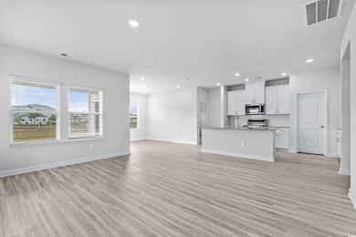 Unfurnished living room featuring light hardwood /
