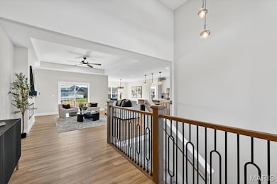 Corridor with light wood-style floors, an upstairs landing, and recessed lighting