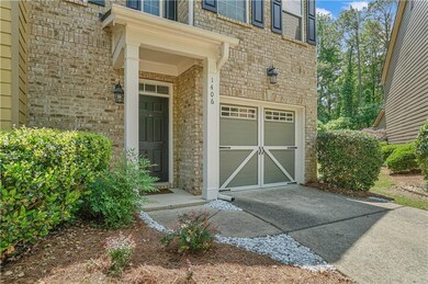 Doorway to property featuring driveway, a garage, and brick siding