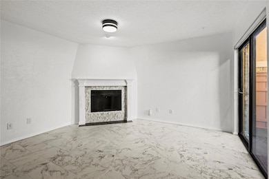 Unfurnished living room featuring a textured ceili