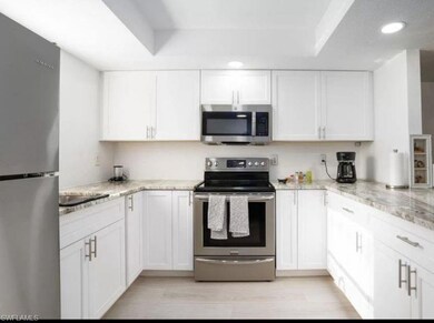 Kitchen with light stone countertops, white cabine