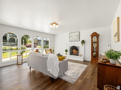 Living area with dark wood-style floors and a brick fireplace