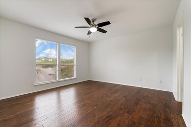 Empty room featuring a ceiling fan and dark wood 