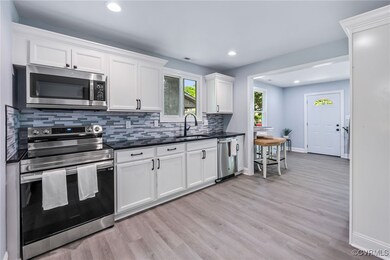 Kitchen featuring backsplash, appliances with stai