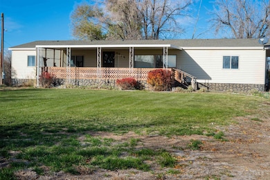 View of front of house with a front lawn, covered porch, and a shingled roof